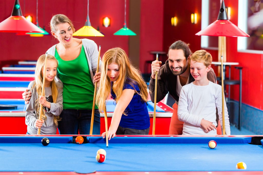 Family playing pool billiard game